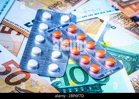 Teller mit Pillen auf dem Hintergrund der Euro-Rechnungen. Das Konzept der teuren Kosten der Gesundheitsversorgung oder Finanzierung der Medizin. Stockfoto