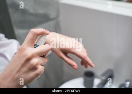Frau mit einer Flasche Handdesinfektionsmittel Stockfoto