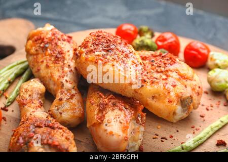 Gekochte Hähnchenschenkelstäbchen mit Gemüse an Bord, Nahaufnahme Stockfoto