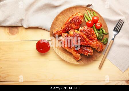 Gekochte Hähnchenschenkel mit Gemüse und Sauce auf dem Tisch Stockfoto