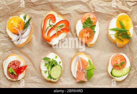 Sandwiches mit leckerem Frischkäse auf Pergament Stockfoto