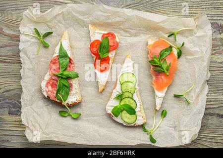 Sandwiches mit leckerem Frischkäse auf Holzhintergrund Stockfoto
