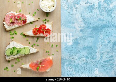 Sandwiches mit leckeren Frischkäse auf farbigem Hintergrund Stockfoto