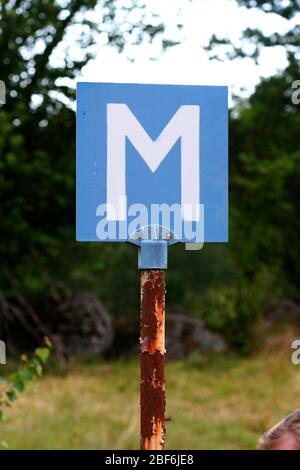 M steht für „MEETING“. Ein altes Schild an einer kleinen Straße. Halten Sie hier Ihr Auto an, um ein anderes vorbeifahren zu lassen. Stockfoto