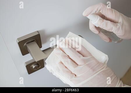 Coronavirus COVID-19 Prävention Reinigung Frau Abwischen Türknauf mit antibakteriellen Desinfektion wischen Stockfoto