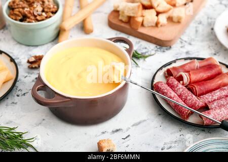 Käsefondue mit Snacks auf weißem Hintergrund Stockfoto