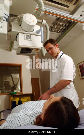 Ein Radiologe richtet die bildgebende Steuereinheit ein, um das Licht auf den gewünschten Bereich des Patienten zu richten Stockfoto