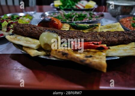 Im türkischen Stil Adana Kebab. Traditionelle türkische Küche Adana Kebab auf hölzernen Tisch. Stockfoto