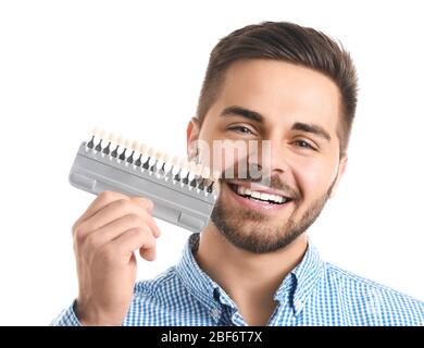 Junger Mann mit Zähnen Farbmustern auf weißem Hintergrund Stockfoto