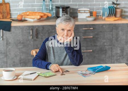 Ältere Frau, die zu Hause Geld zählt Stockfoto