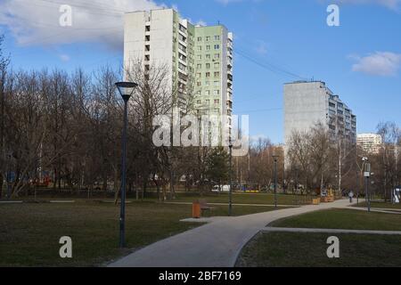 Moskau, Russland - 22. März 2020: Blick auf den Park im Frühling mit pedestian Gehweg und Bank in Juschnoje Medwedkovo Bezirk. Stockfoto