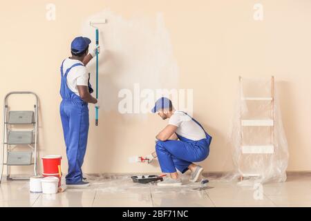 Männliche Maler, die im Zimmer Reparatur machen Stockfoto