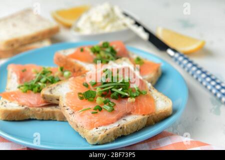 Sandwiches mit leckerem Frischkäse und Lachs auf dem Teller Stockfoto