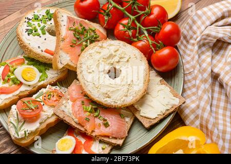 Verschiedene Sandwiches mit leckerem Frischkäse auf dem Teller Stockfoto