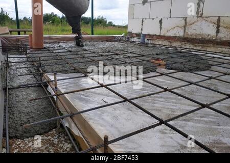 Gießen von Beton nach dem Platzieren von Stahlarmierung zu einem Estrich zu machen, zeigt das Foto Kanalrohre. 2019 Stockfoto