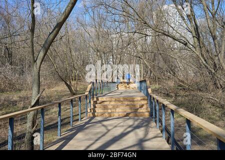 Mann in blauer Kleidung geht die Holztreppe im Park im Bezirk Juschnoje Medwedkowo, Moskau Stockfoto