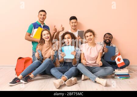 Junge Schüler der Sprachschule sitzen in der Nähe von Farbwand Stockfoto