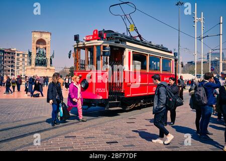 Nostalgische Rote Straßenbahn in der Taksim Istiklal Straße um 12 Uhr mittags. Die Taksim Istiklal Straße ist ein beliebtes Ziel in Istanbul. Beyoglu, Taksim, Istanbul. Türkei. Stockfoto