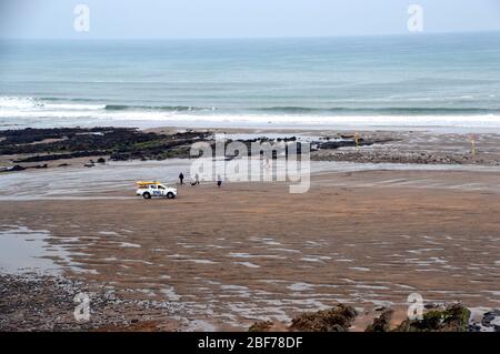 RNLI Rettungsschwimmer im Geländewagen am Sandstrand in der Widemouth Bay vom Clifftop-Wanderweg auf dem South West Coast Path, North Cornwall, England, Großbritannien. Stockfoto