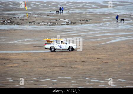 RNLI Rettungsschwimmer im Geländewagen am Sandstrand in der Widemouth Bay vom Clifftop-Wanderweg auf dem South West Coast Path, North Cornwall, England, Großbritannien. Stockfoto