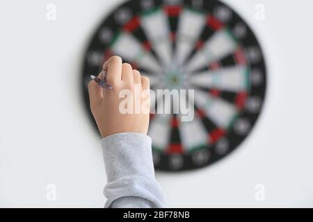 Junge Frau, die Darts in Innenräumen spielt Stockfoto