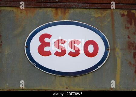 Altes Esso-Schild, eine Benzingesellschaft, die auf einer rostigen Wand sitzt. Stockfoto