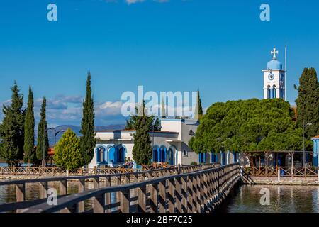 PORTO LAGOS, GRIECHENLAND - 29. NOVEMBER 2019: Touristen genießen das schöne Kloster St. Nikolaus am Vistonida-See, Porto Lagos, Xanthi Region in Nordgriechenland, Blick mit der Wasserbrücke Stockfoto