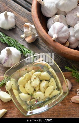 Schüssel mit Knoblauch und Öl auf Holztisch Stockfoto