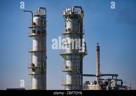 Nahaufnahme von Öl Graue Destillationstürme (Raffiniersäulen) am blauen Himmel. Auf petrochemischen Anlagen. Gasbrenner Turm auf Hintergrund. Stockfoto