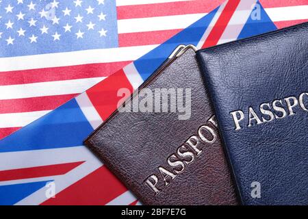 Pässe auf US-amerikanischen und britischen Flaggen. Einwanderungskonzept Stockfoto