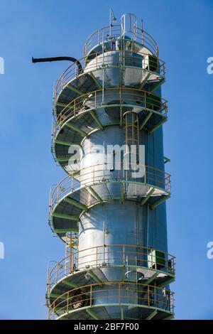 Nahaufnahme des Destillationsturms aus grauem Metall. Ölraffinierungssäule am blauen Himmel. Petrochemische Anlage. Stockfoto