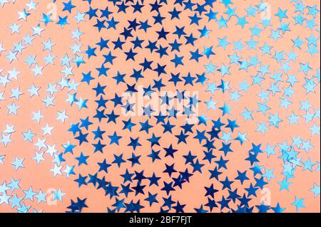 Festlicher Hintergrund von sanfter Orange Farbe mit blau funkelnden Sternen. Stockfoto