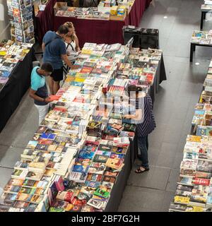 Buchmarkt im Haus. Ehrliche Ansicht einer Gruppe von Kunden, die an den Ständen eines Buchmarktes in einem Gebäude stöbern. Stockfoto