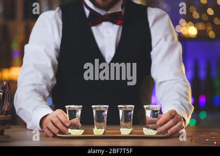 Schöner Barkeeper mit Tequila-Schüssen im Pub Stockfoto