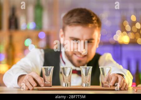 Schöner Barkeeper mit Tequila-Schüssen im Pub Stockfoto