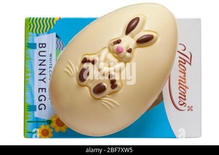 Thorntons weiße Schokolade Bunny Egg aus der Box entfernt und auf der Oberseite platziert - Osterhasen Kaninchen Ei isoliert auf weißem Hintergrund bereit für Ostern Stockfoto