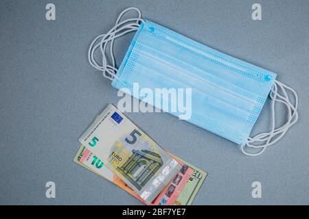 Medizinische Gesichtsmaske und Geld, Welt Coronavirus Epidemie und wirtschaftliche Schäden. Coronavirus-Konzept. Stockfoto