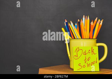 Becher mit Bleistiften in der Nähe der Schule Tafel Stockfoto