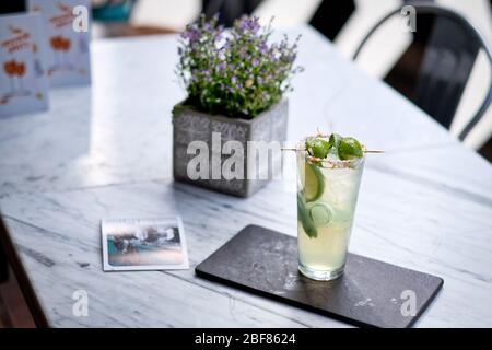 Erfrischter Mojito-Cocktail mit Plätzchen auf dem Marmortisch. Sommer exotisch bunten Cocktail Stockfoto