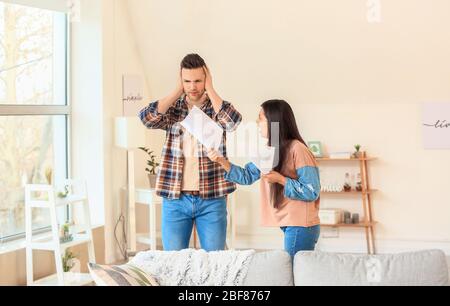 Missfiel Frau schimpft ihren Mann für zu viel Ausgaben zu Hause Stockfoto