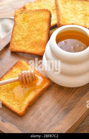 Süßer Honig und geröstetes Brot auf dem Tisch Stockfoto