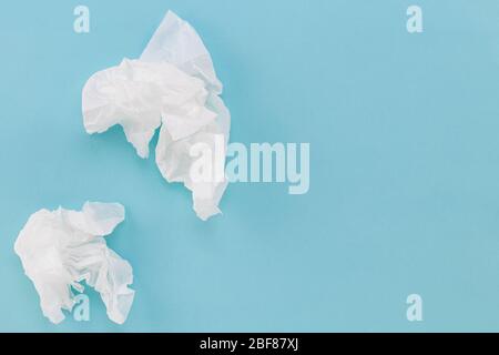 Gebrauchtes Papierhandtuch auf blauem Hintergrund. Konzept für Gesundheitspflege und Erkältungen. Kopierbereich. Stockfoto