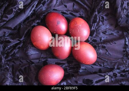 Rot bemalte Eier mit Blumen und Kerzen für die Feier Osterferien Stockfoto