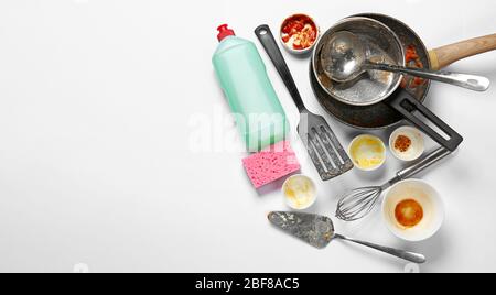 Schmutziges leeres Geschirr mit Waschmittel und Schwamm auf weißem Hintergrund Stockfoto