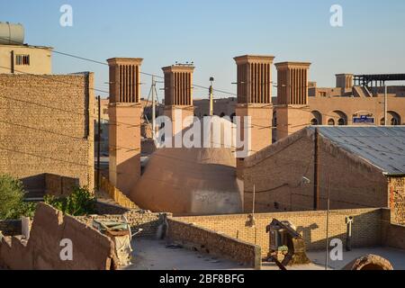 Blick über die Altstadt von Yazd, Iran, mit Windtürmen, die einen kuppelförmigen Wasserreservoir umgeben Stockfoto