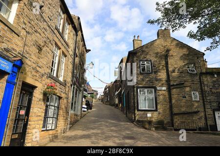 Die Aussicht auf die gepflasterte Hauptstraße in Haworth, West Yorkshire. Haworth war die Heimat der Bronte Schwestern und ist ein beliebtes Touristenziel. Stockfoto