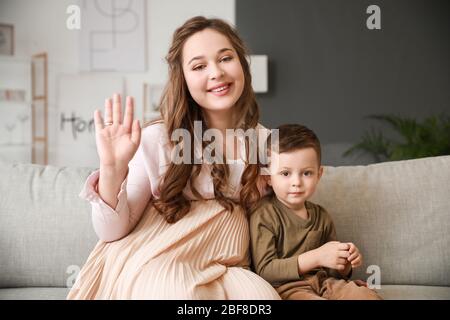 Schwangere Frau und ihr kleiner Sohn Video-Chat zu Hause Stockfoto