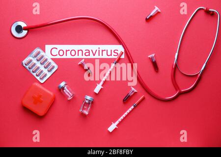 Reagenzgläser mit Blutprobe und Medikamenten für Coronavirus auf farbigem Hintergrund Stockfoto