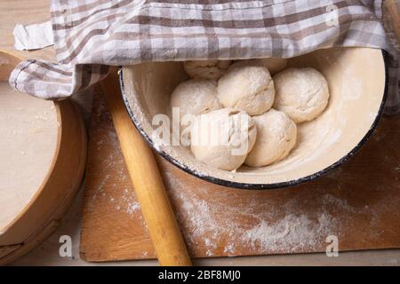 Teigkugeln sind in einer großen gelben Schüssel. Kochen zu Hause. Stockfoto