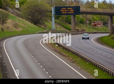 East Lothian, Schottland, Großbritannien, 17. April 2020. Covid-19 Sperrung auf der A1: Als das Land in die zweite Phase der angekündigten Verlängerung der Sperrmaßnahmen eintritt, ist die normalerweise verkehrsreiche A1-Schnellstraße, die Schottland mit England verbindet, fast menschenleer und mit sehr wenig Verkehr außer denen, die auf wesentlichen Reisen unterwegs sind. Eine Überkopfportal hat die Pandemiemeldung Bleib sicher, schütze NHS, Save Lives Stockfoto